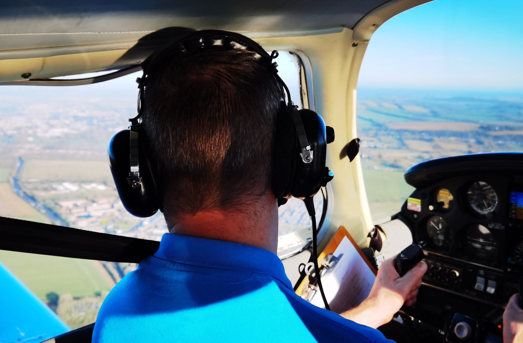 Male Flying Light Aircraft over Fields